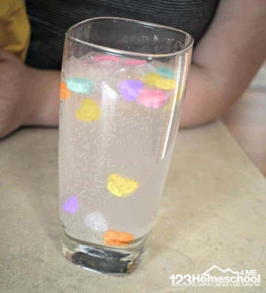 Make conversation heart candy dance in a glass of water using simple science experiment in this valentines day activity for toddler, preschool, prek, kindergarten, 1st grade, and 2nd grade kids